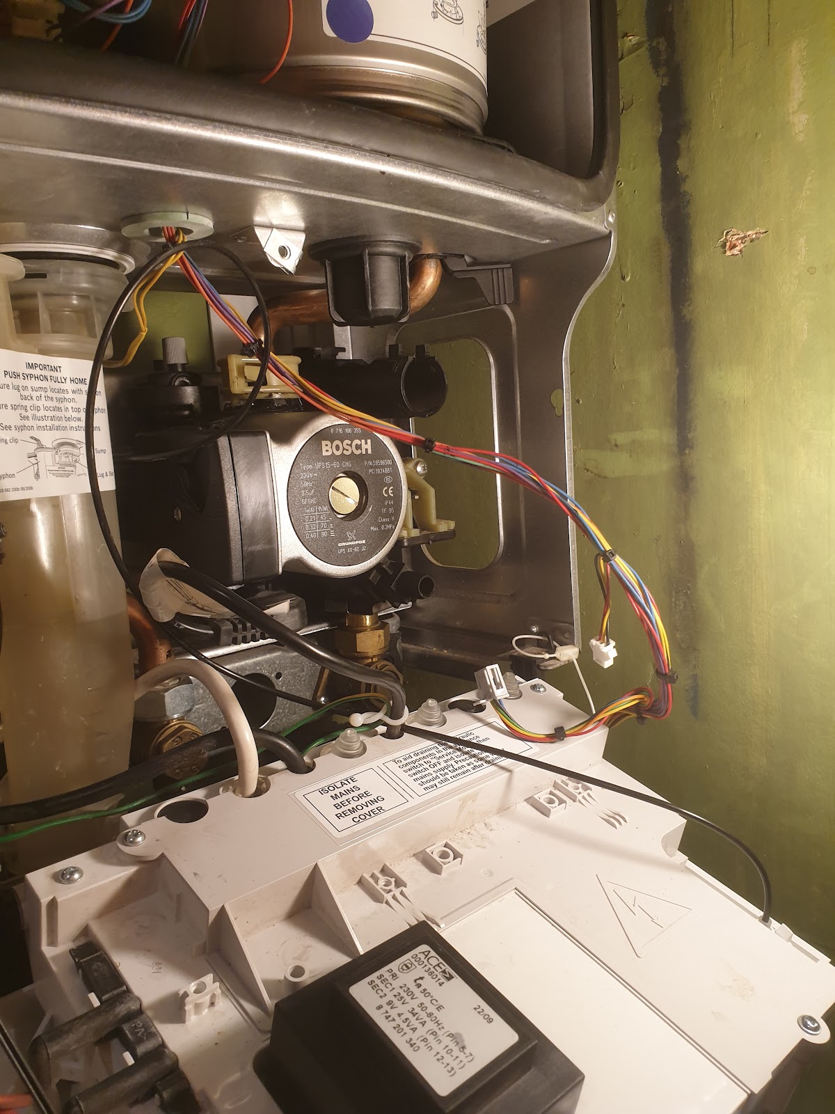 Boiler opened up for repair showing the pump and internal wiring